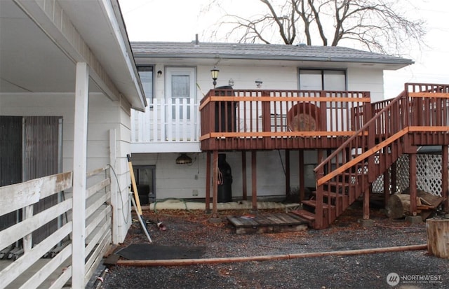 rear view of house with stairway and a deck