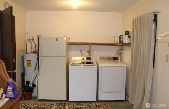 clothes washing area featuring laundry area, water heater, separate washer and dryer, and a textured ceiling