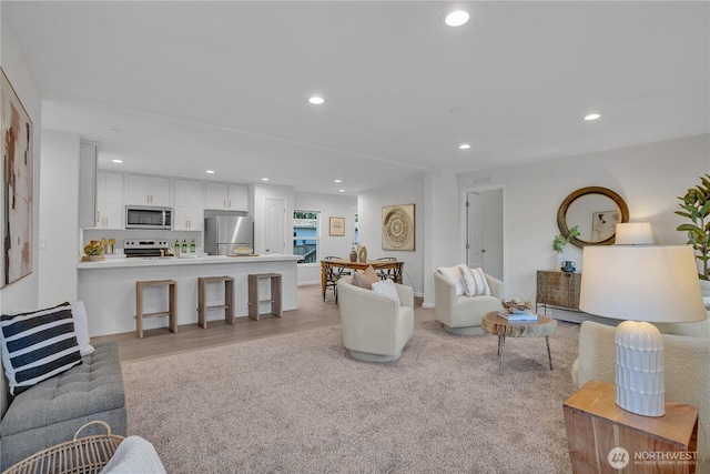 living room featuring light colored carpet and recessed lighting