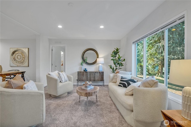 carpeted living area featuring baseboards, visible vents, and recessed lighting