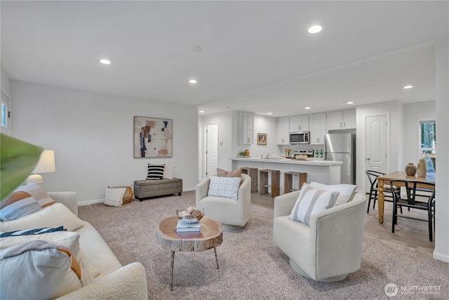 living area featuring recessed lighting and baseboards