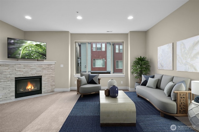 living room featuring recessed lighting, baseboards, carpet flooring, and a stone fireplace