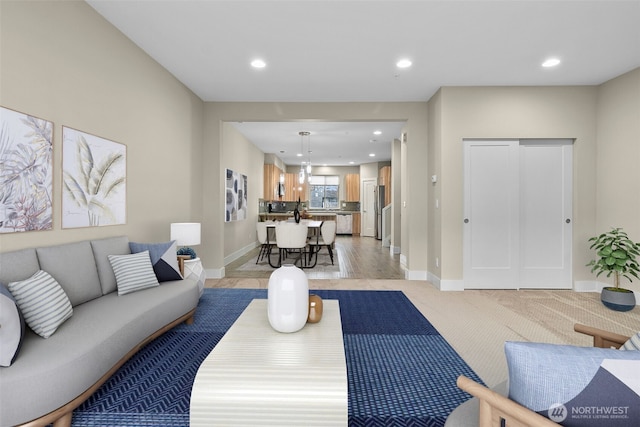 living area featuring baseboards, light colored carpet, and recessed lighting