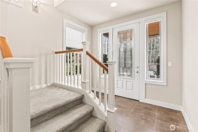 foyer featuring tile patterned flooring, baseboards, and stairs