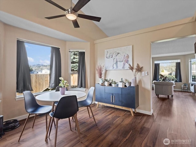 dining area featuring vaulted ceiling, baseboards, and wood finished floors