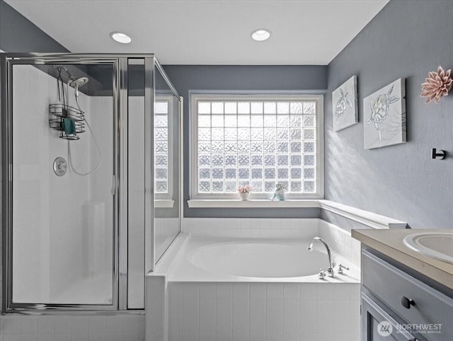 bathroom with recessed lighting, a garden tub, a shower stall, and vanity