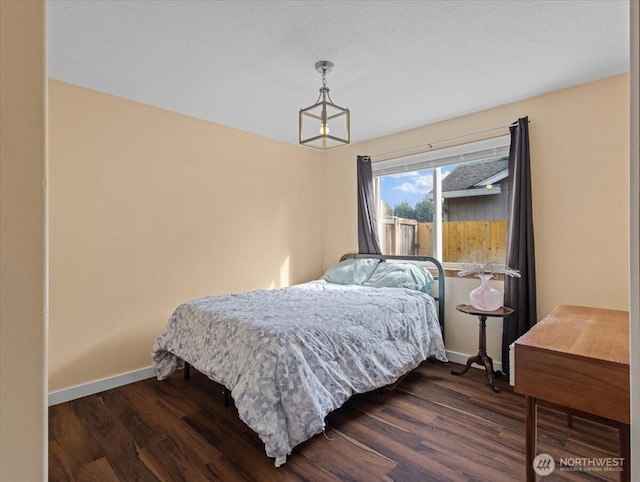 bedroom with dark wood-style floors and baseboards