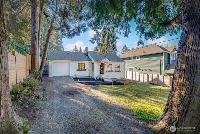 single story home featuring a garage, driveway, a front lawn, and fence