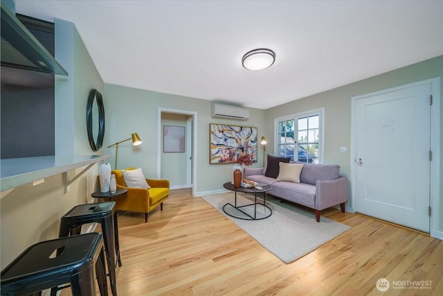 living area featuring light wood-style flooring, baseboards, and a wall mounted AC