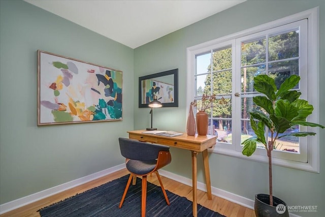 office area with baseboards, wood finished floors, and a healthy amount of sunlight