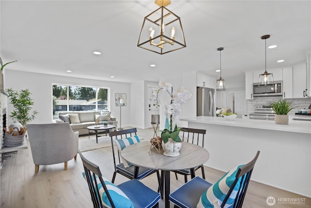 dining area featuring light wood finished floors and recessed lighting