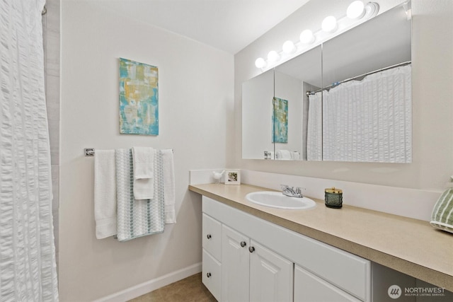 bathroom with tile patterned flooring, vanity, and baseboards