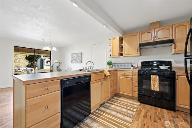 kitchen featuring light wood finished floors, a peninsula, under cabinet range hood, black appliances, and light brown cabinets