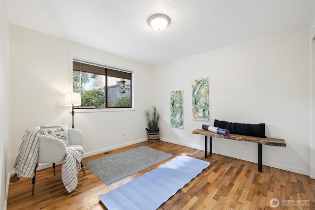 home office featuring wood finished floors, visible vents, and baseboards