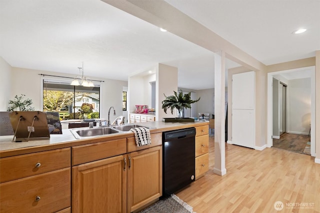 kitchen featuring recessed lighting, a sink, light countertops, dishwasher, and light wood finished floors