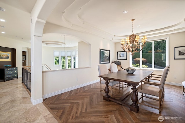 dining space featuring recessed lighting, a raised ceiling, a notable chandelier, and baseboards