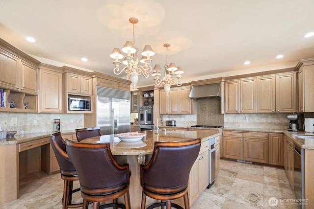 kitchen featuring built in appliances, light stone counters, a kitchen island with sink, a kitchen breakfast bar, and wall chimney exhaust hood