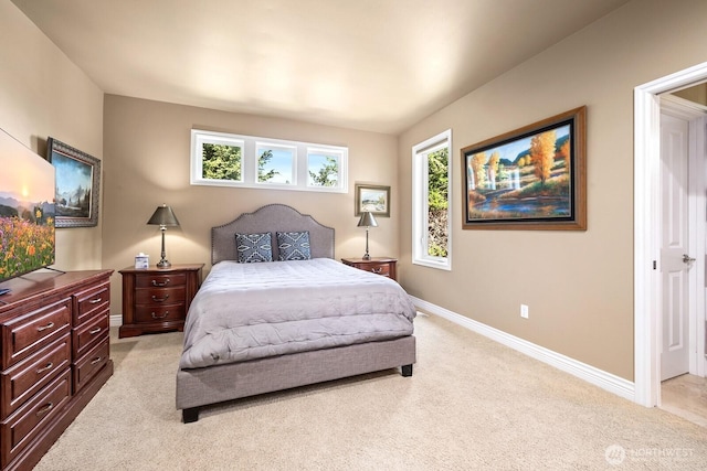 bedroom with multiple windows and light colored carpet