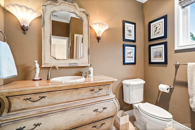 bathroom featuring baseboards, vanity, and toilet