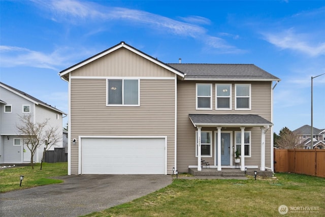 traditional-style home with driveway, fence, covered porch, a front yard, and a garage