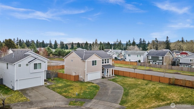 exterior space featuring a residential view, driveway, an attached garage, and fence