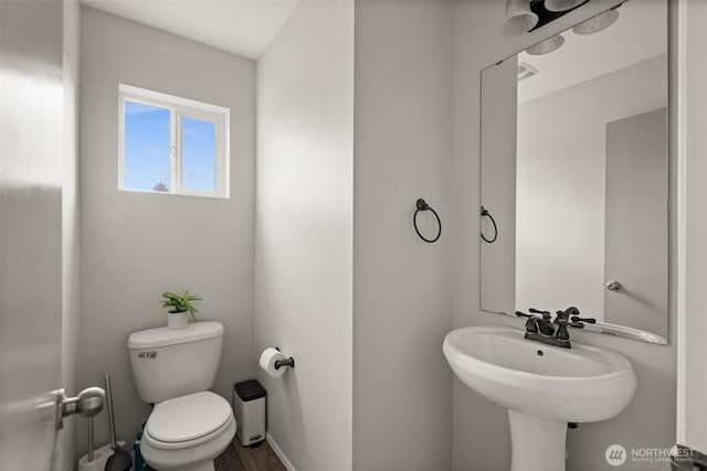 half bath with toilet and baseboards