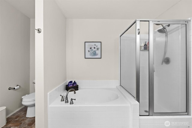 bathroom with stone finish flooring, baseboards, toilet, a garden tub, and a stall shower