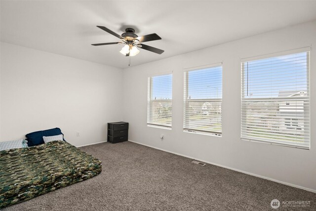 carpeted bedroom with visible vents, multiple windows, and baseboards