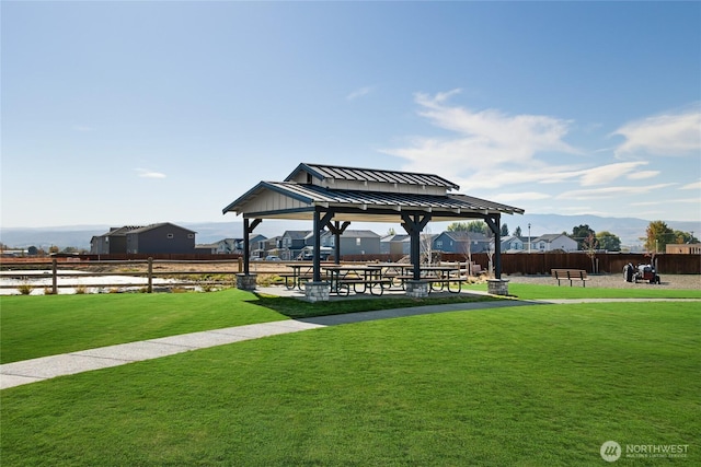 view of community featuring a yard, fence, and a gazebo