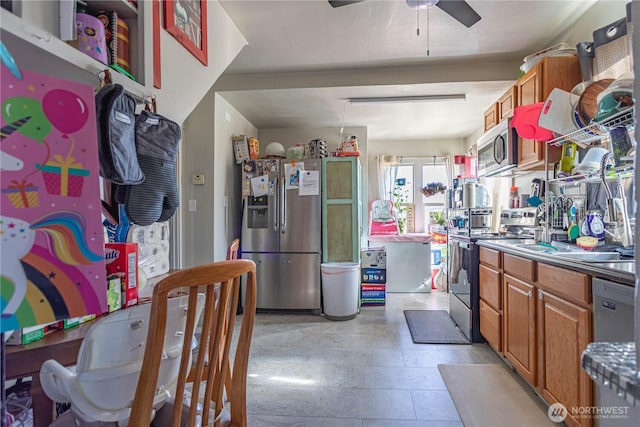 kitchen with appliances with stainless steel finishes, brown cabinets, and ceiling fan