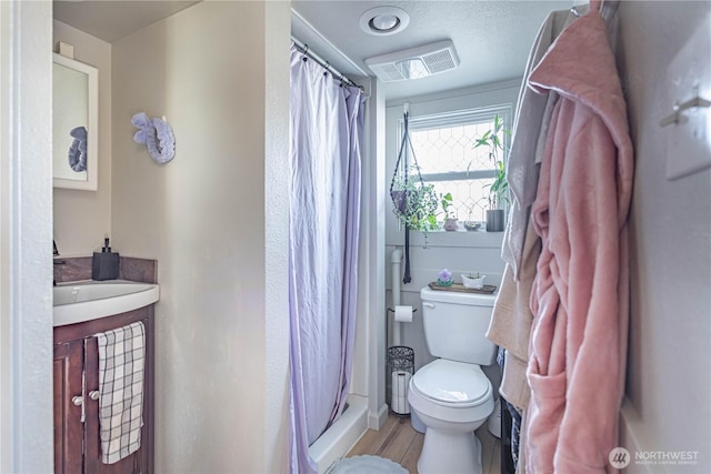 bathroom featuring a shower stall, visible vents, vanity, and toilet