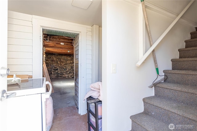 stairs featuring unfinished concrete flooring