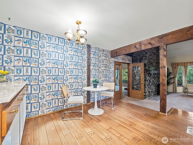 dining area featuring hardwood / wood-style flooring, a chandelier, and beamed ceiling