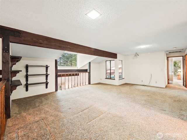 unfurnished living room with visible vents, carpet flooring, vaulted ceiling with beams, and a textured ceiling