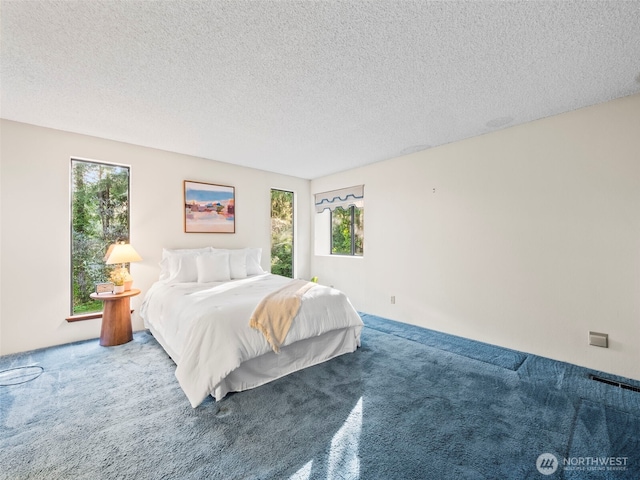 bedroom featuring a textured ceiling, carpet, and visible vents