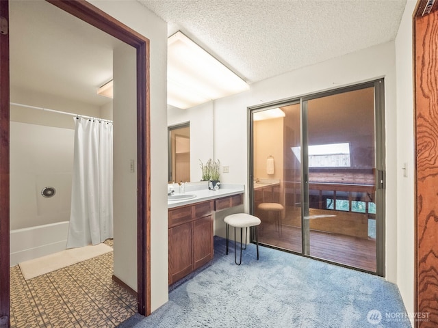 bathroom with a textured ceiling, shower / bath combo with shower curtain, and vanity