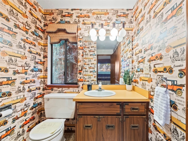 half bathroom with toilet, wallpapered walls, and vanity