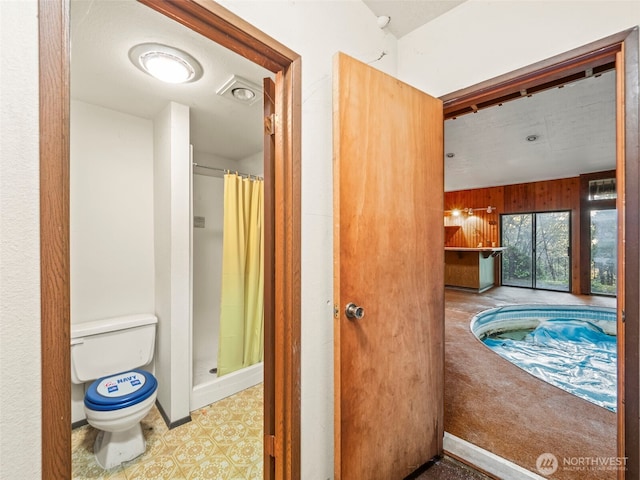 full bathroom with a shower stall, toilet, and tile patterned floors