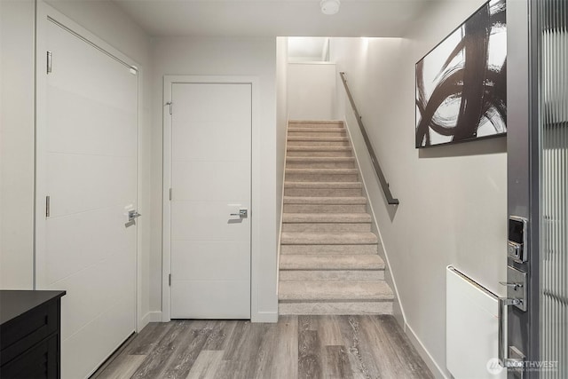 stairway with baseboards and wood finished floors