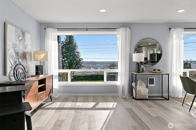 interior space with baseboards, wood finished floors, and recessed lighting