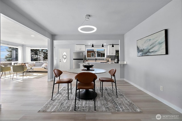 dining room featuring baseboards and light wood finished floors