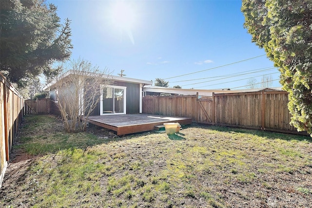 back of house featuring a yard, a fenced backyard, and a wooden deck