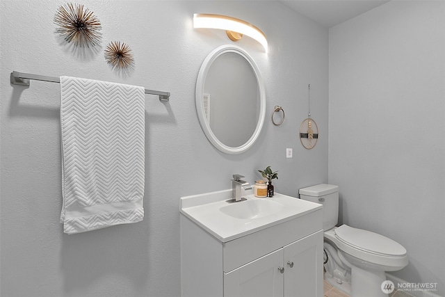 half bathroom with vanity and toilet