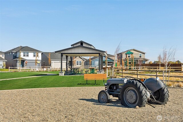 community jungle gym featuring a residential view, a lawn, and fence