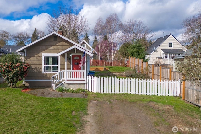 bungalow featuring fence, a chimney, and a front lawn