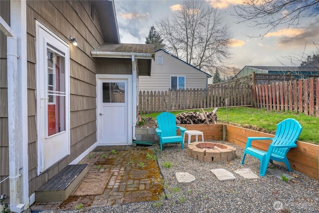 patio terrace at dusk featuring fence and a fire pit