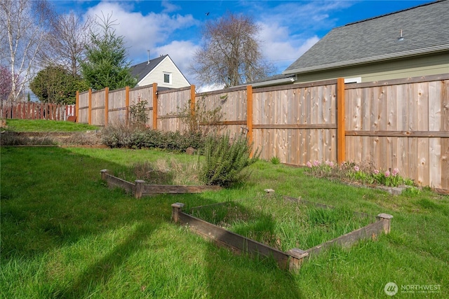 view of yard featuring fence and a garden