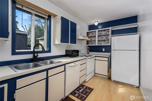 kitchen featuring light countertops, light wood-style flooring, a sink, white appliances, and under cabinet range hood