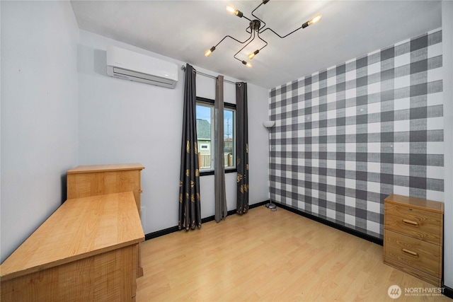 interior space featuring light wood-style floors, an accent wall, baseboards, and a wall mounted AC