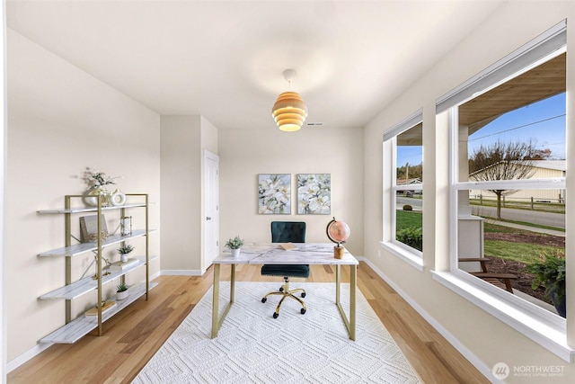 office space with visible vents, baseboards, and wood finished floors